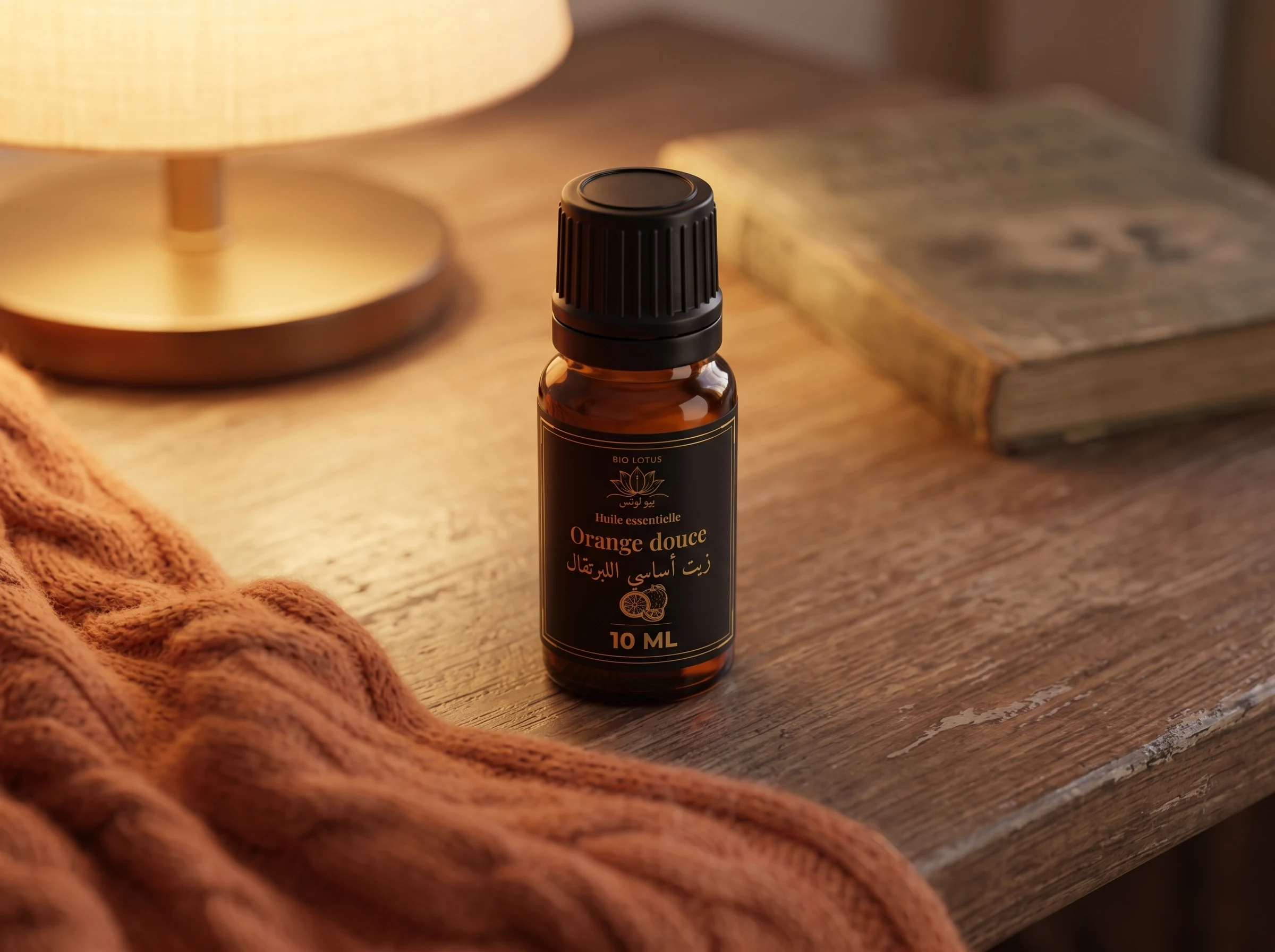 Flacon d'huile essentielle d'orange douce Bio Lotus dans une ambiance cocooning du soir